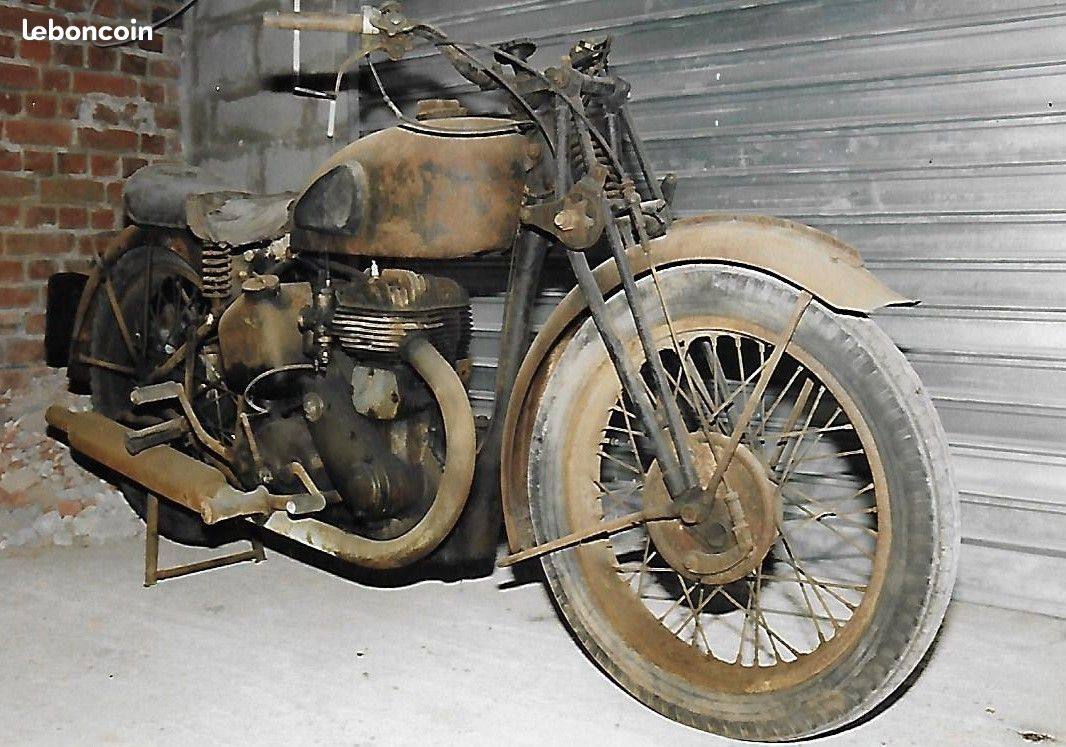Complete but heavily weathered BSA KM20 standing in front of a metal garage door.