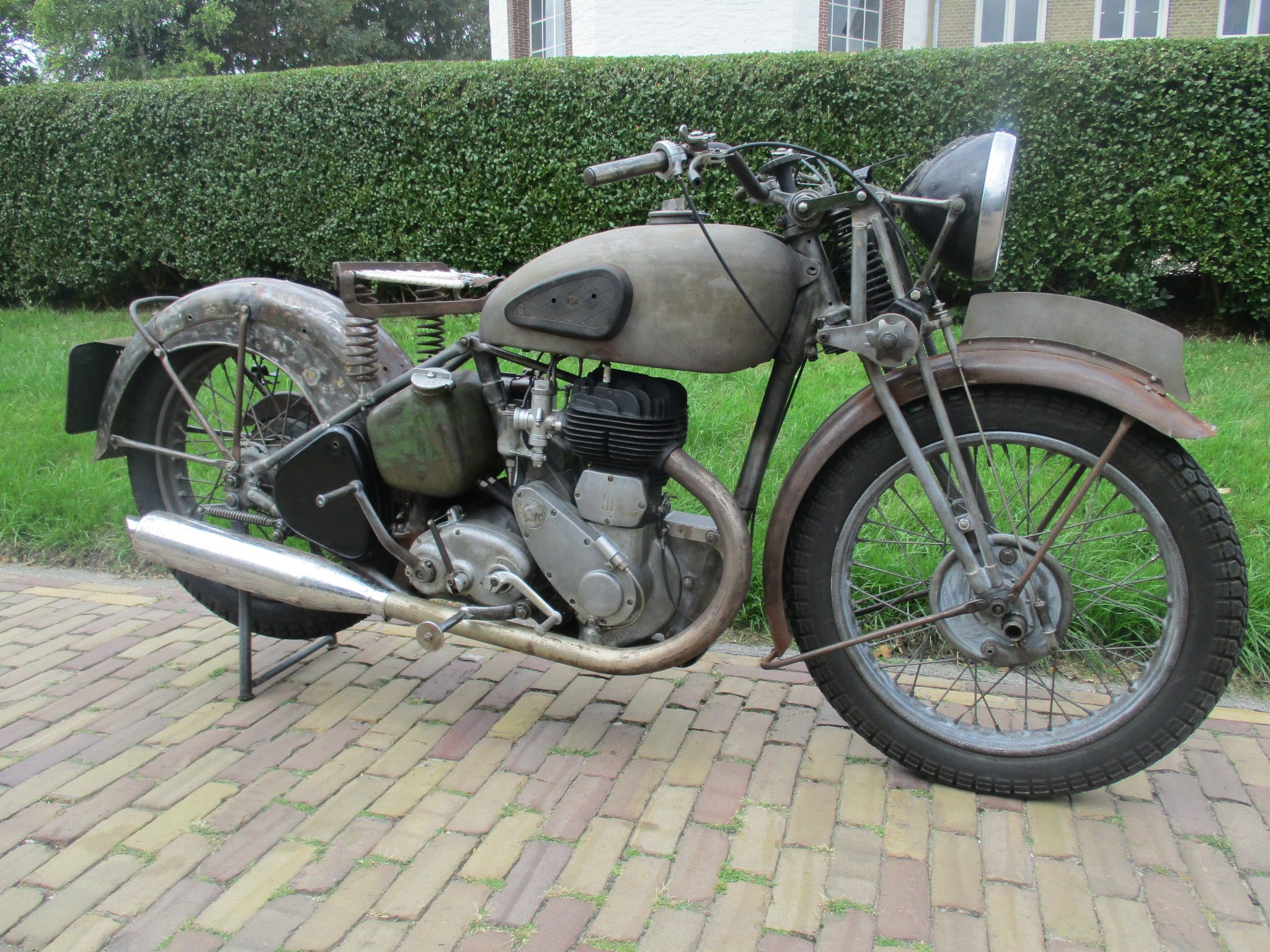 Reassembled unpainted BSA KM20 standing outside on brick paving.