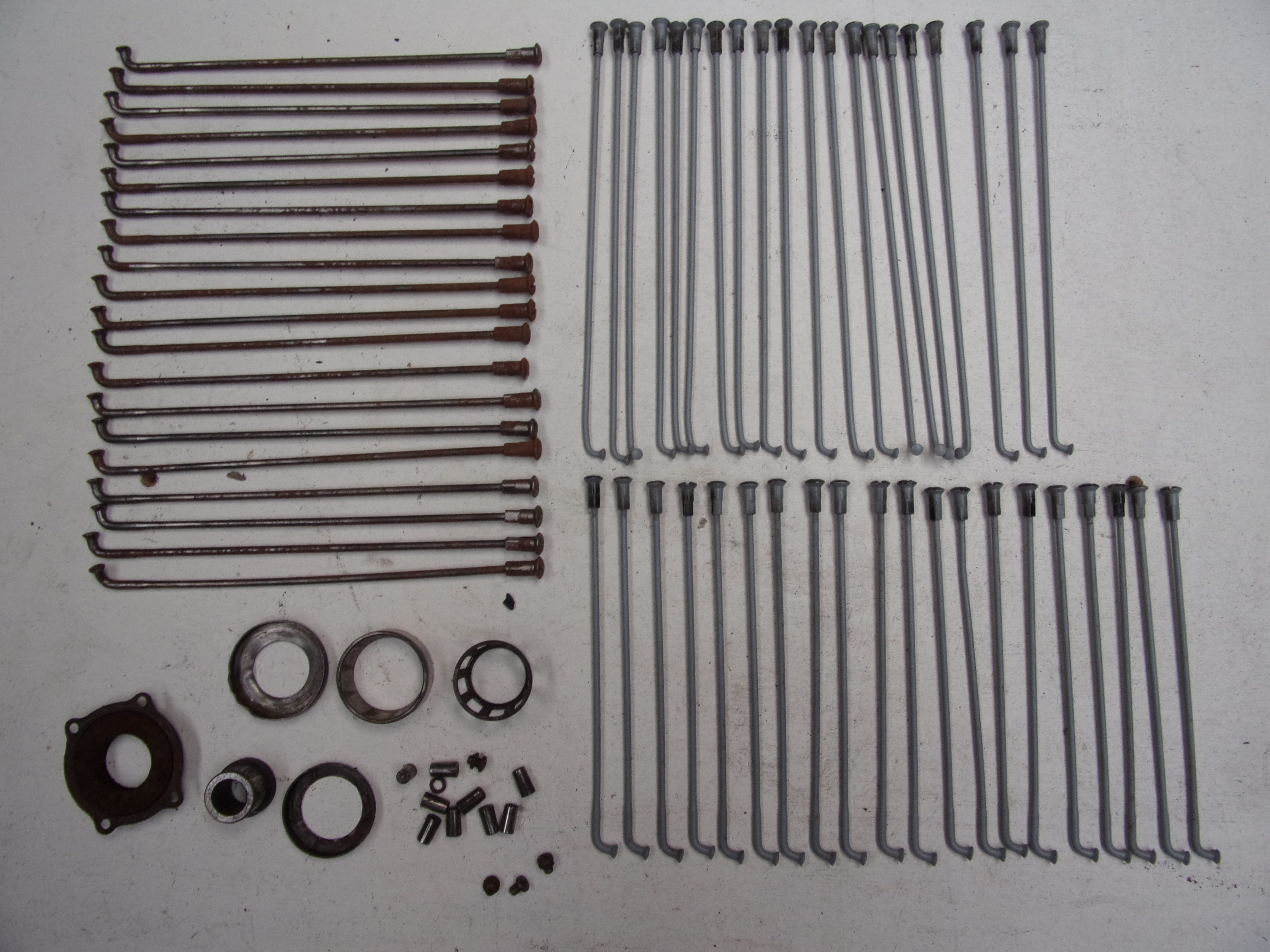 Rows of original and refinished wheel spokes arranged on a pale work surface.