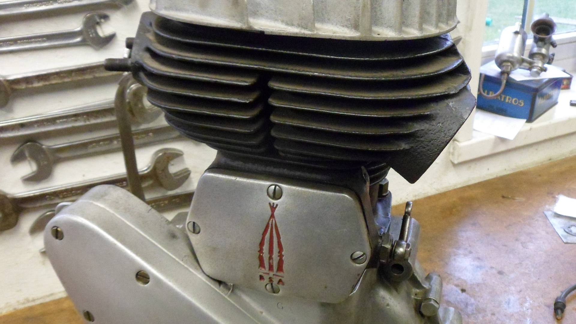 Close view of a BSA single-cylinder engine on a workshop bench.