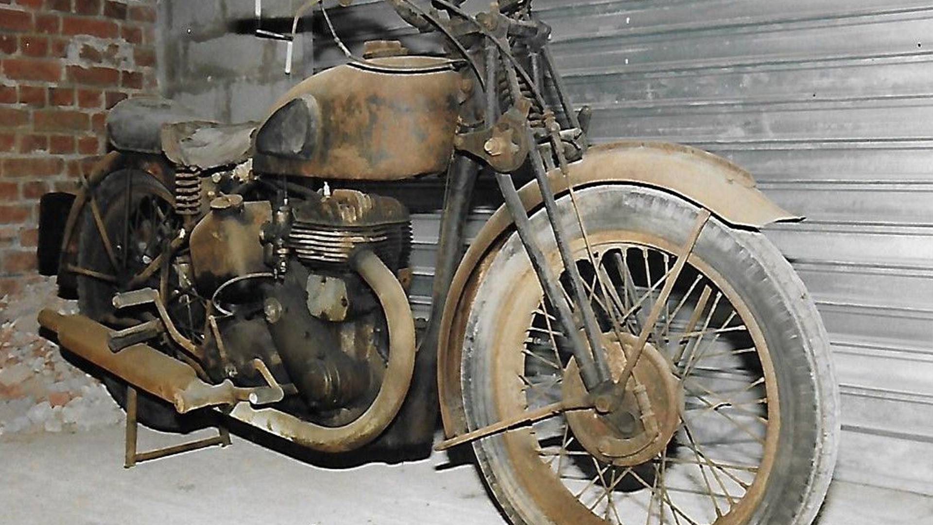 Partly dismantled, unrestored BSA motorcycle with girder forks in a workshop.