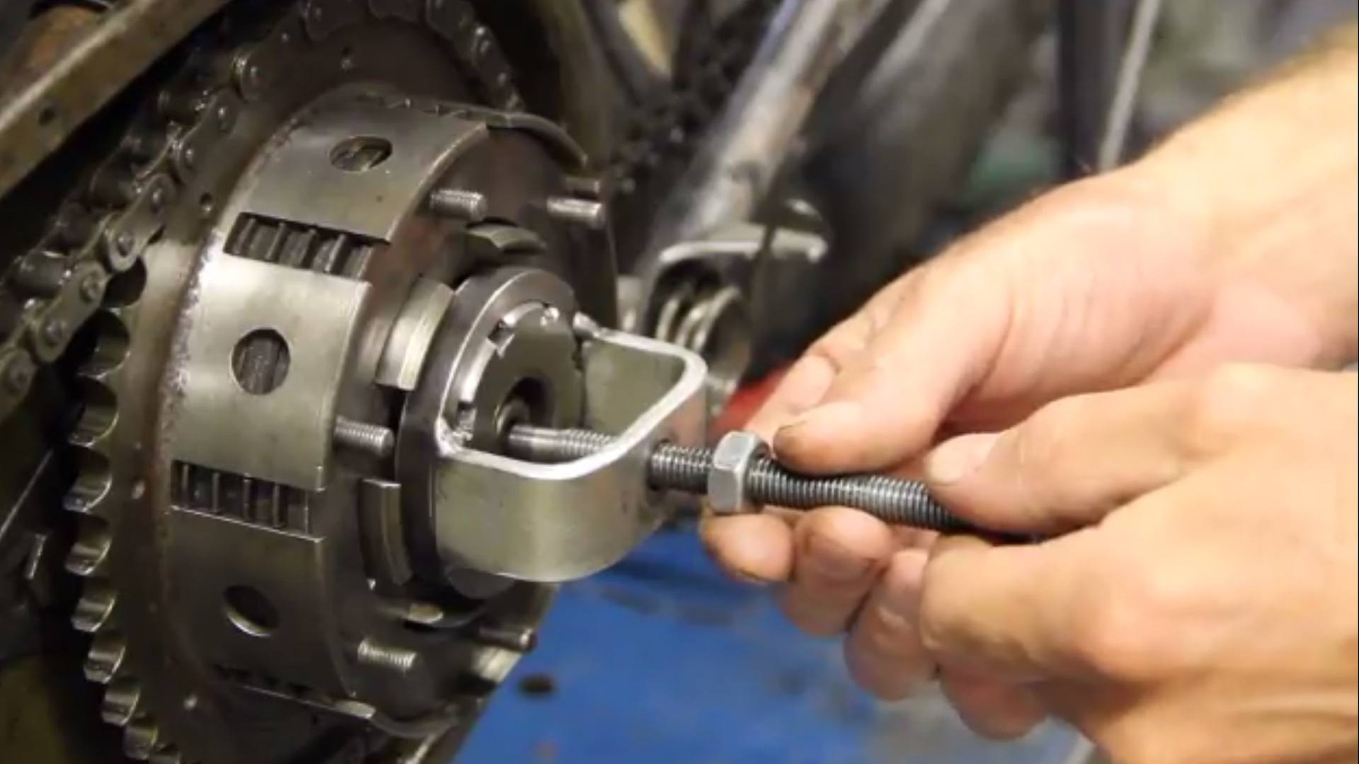 Hands fitting a workshop compression tool to a BSA clutch.
